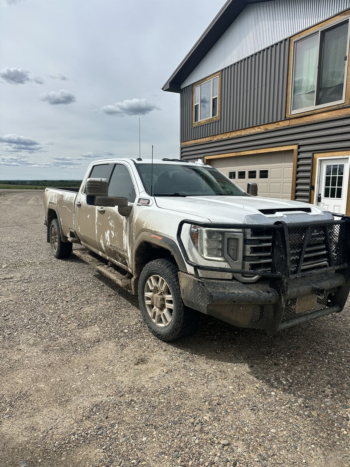 White GMC Sierra 3500 HD caked in farm mud